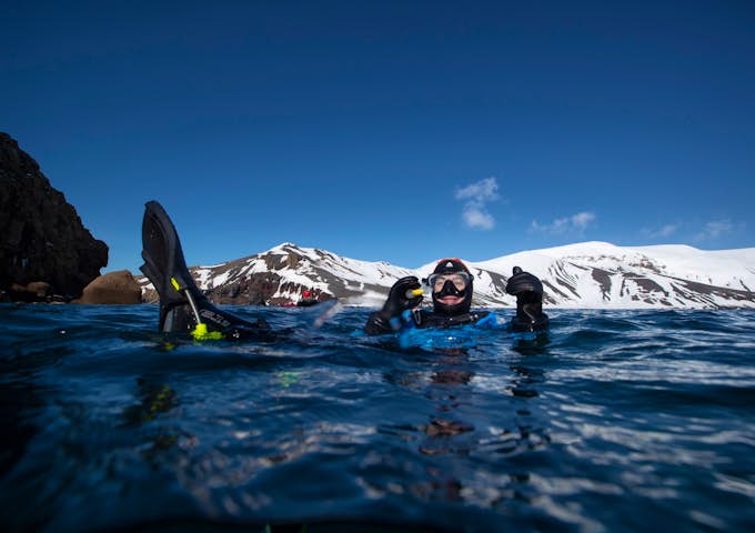 Snorkeller gives a thumbs up while in the Antarctic waters