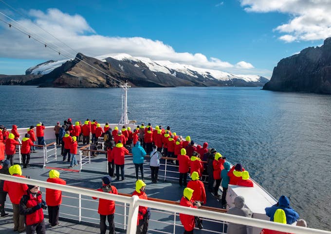 People stand out on deck at Whalers Bay in Antarctica