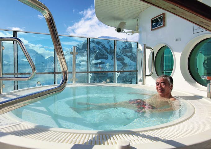 A man enjoys the hot tub and views on an Antarctic cruise ship 