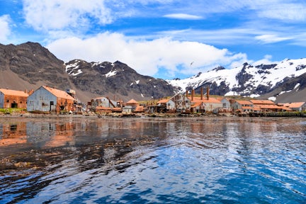 Rusting ruins of the abandoned Stromness Harbour whaling station on South Georgia, with mountains in the background