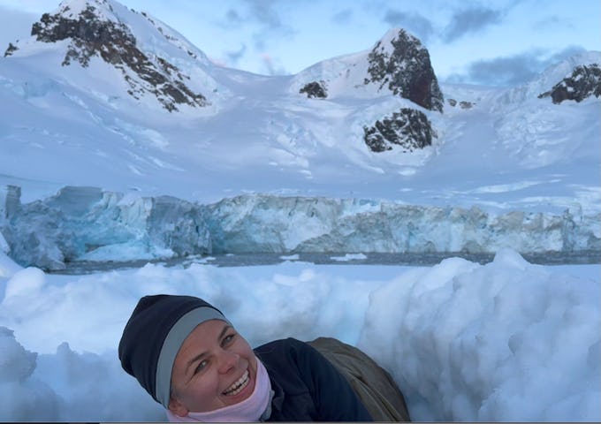 A tourist camping in a snowhole in Antarctica