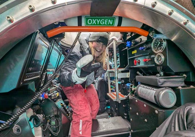 A women waves as she enters a submarine in Antarctica