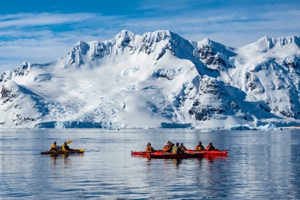 A group of tourists paddling in kayaks off Pleneau Island in the Antarctic Peninsula