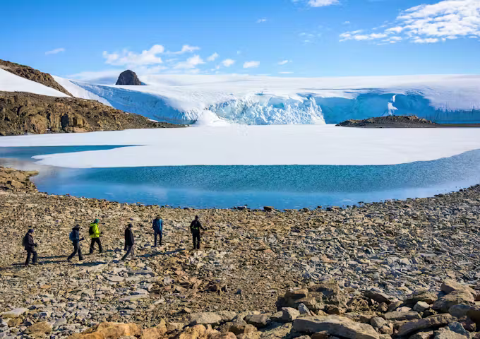 Hikers at a glacial lake in the Antarctic interior